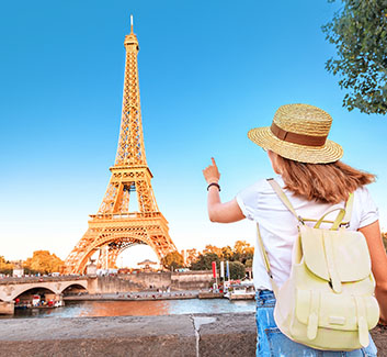 Woman looking a the Eiffel Tower in Paris, France.