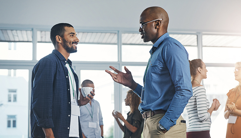 Colleagues talking face to face at a networking event.