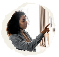 Woman setting back her thermostat at home.